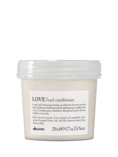 Transparente Dose mit cremigem Conditioner der Marke Davines, Produktname „LOVE Curl Conditioner“