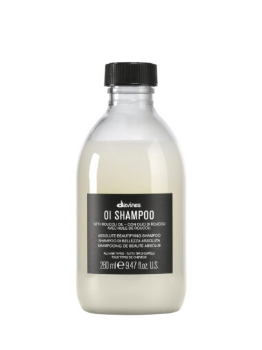 Transparente Flasche mit glänzendem Shampoo der Marke Davines, Produktname „OI Shampoo“