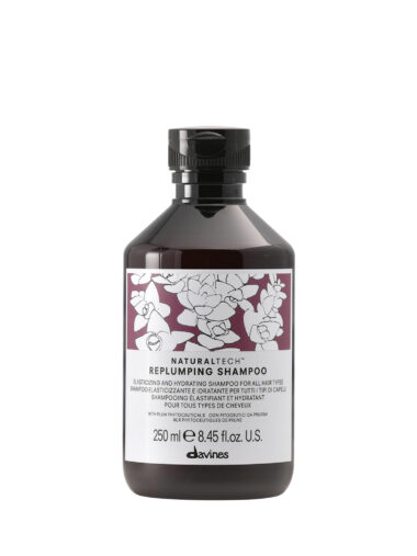 Transparente Flasche mit voluminösem Shampoo der Marke Davines, Produktname „Replumping Shampoo“